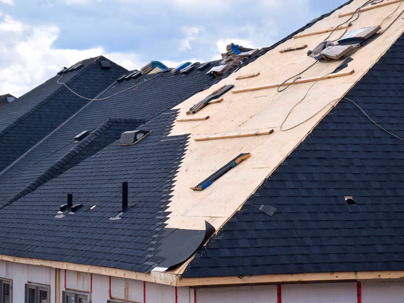 Roofer installing shingles on a residential roof